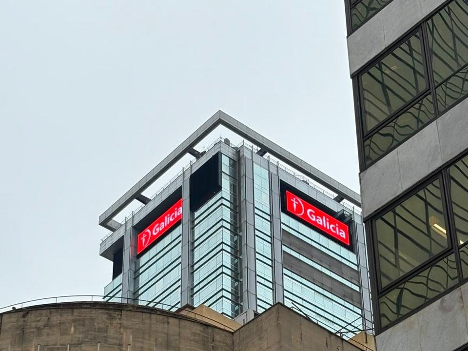 Vista del coronamiento LED de Banco Galicia desde la calle, con el edificio del Banco Provincia en primer plano