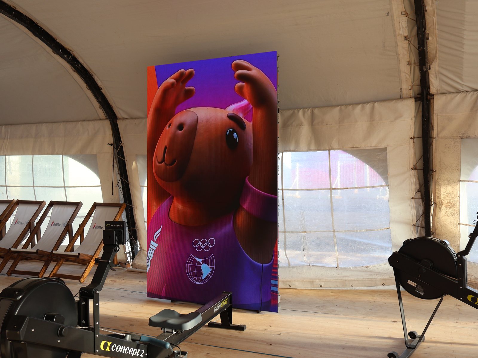 Pantalla LED vertical de Prina con la mascota de los Juegos Suramericanos dentro de un gimnasio